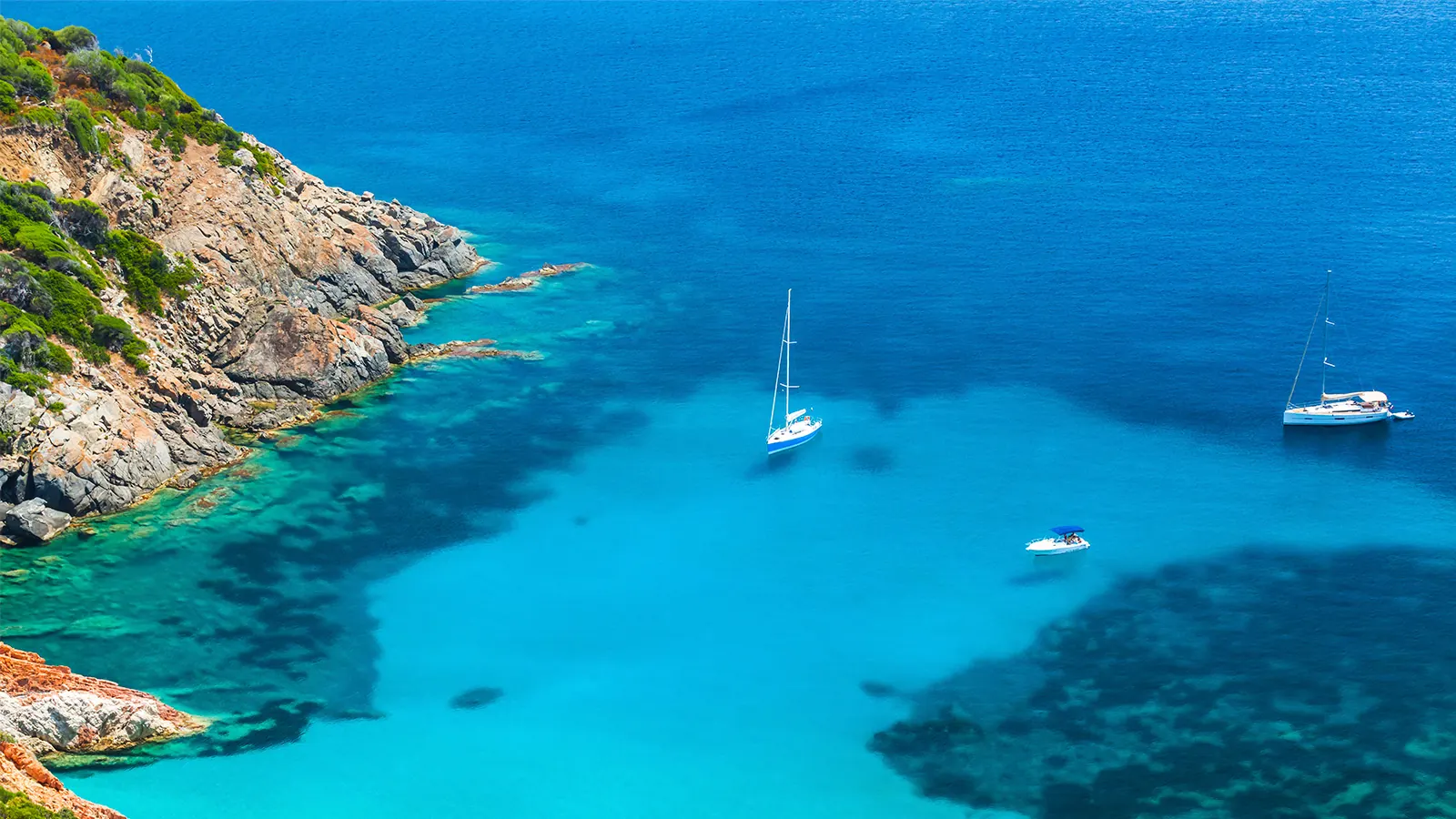 Voiliers au mouillage dans une crique aux eaux turquoise